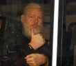 Julian Assange in handcuffs thumbs up